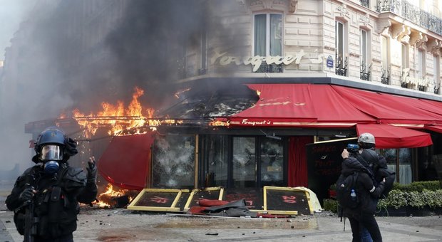 Gilet gialli, guerriglia a Parigi: palazzo in fiamme, negozi assaliti. Castaner: «Assassini»